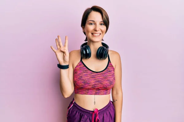 Młoda Brunetka Krótkimi Włosami Ubrana Odzież Sportową Słuchawki Pokazując Wskazując — Zdjęcie stockowe