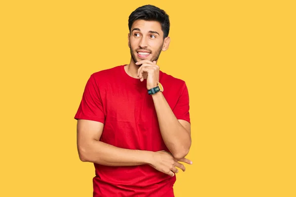 Joven Hombre Guapo Con Camiseta Roja Casual Con Mano Barbilla —  Fotos de Stock