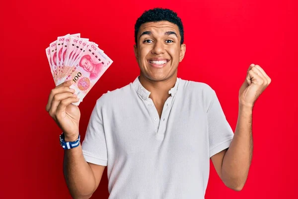 Joven Árabe Sosteniendo Billetes Chinos Yuan Gritando Orgulloso Celebrando Victoria —  Fotos de Stock