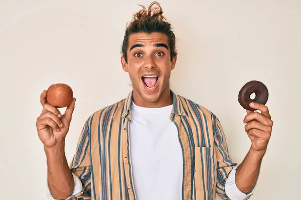 Joven Hombre Hispano Sosteniendo Manzana Roja Donut Celebrando Loco Sorprendido —  Fotos de Stock