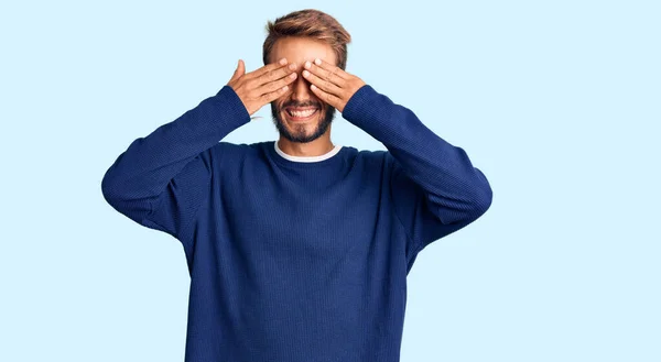 Przystojny Blondyn Brodą Ubrany Luźny Sweter Zakrywający Oczy Uśmiechniętymi Dłońmi — Zdjęcie stockowe