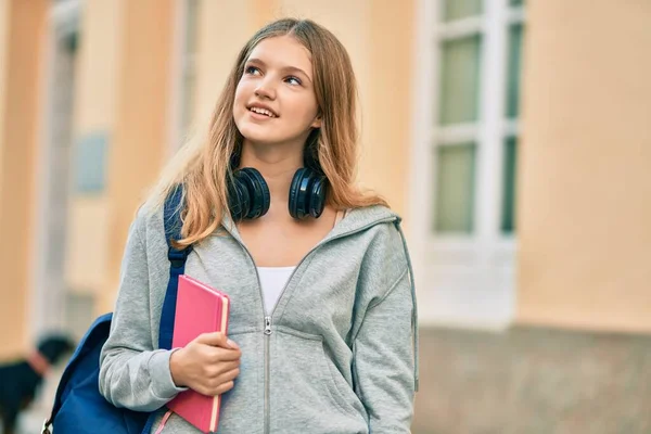 Όμορφη Καυκάσιος Έφηβος Φοιτητής Χρησιμοποιώντας Ακουστικά Κρατώντας Βιβλίο Στην Πόλη — Φωτογραφία Αρχείου