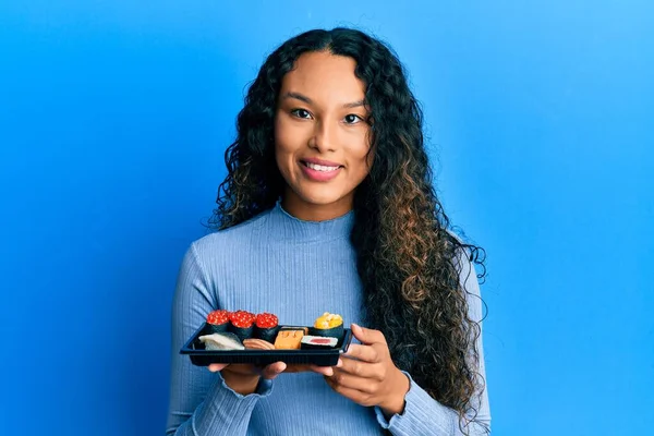 Jonge Latijnse Vrouw Toont Een Bord Van Sushi Kijken Positief — Stockfoto
