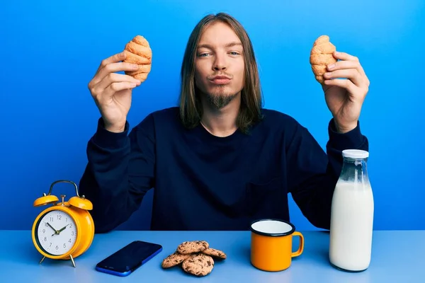 Jóképű Fehér Férfi Hosszú Hajjal Croissant Eszik Reggelire Kamerába Néz — Stock Fotó