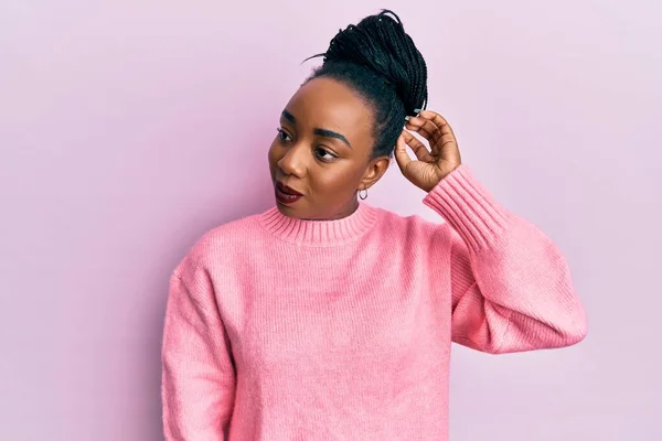 身穿休闲式冬季毛衣的年轻的非洲裔美国女人对这个问题感到困惑和疑惑 拿不定主意 手拿着头思考 沉思的概念 — 图库照片
