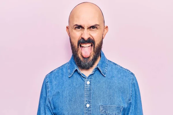 Sıradan kıyafetler giyen genç yakışıklı bir adam komik bir ifadeyle dilini dışarı çıkartıyor. duygu kavramı. 