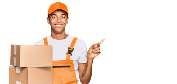 Jovem Afro Americano Bonito Segurando Pacote Entrega Sorrindo Feliz Apontando — Fotografia de Stock