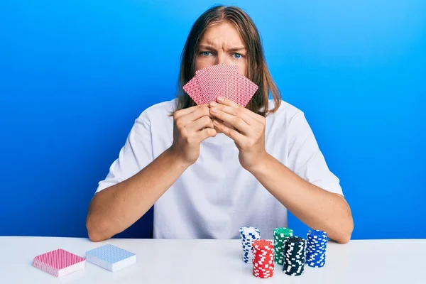 Bonito Homem Caucasiano Com Cabelos Longos Jogando Poker Cobrindo Rosto — Fotografia de Stock