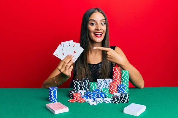 Jovem Hispânica Sentada Mesa Jogando Poker Segurando Cartas Sorrindo Feliz — Fotografia de Stock