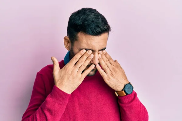 疲労感や頭痛 疲れた表情のために目をこすりカジュアルな服を着て若いヒスパニック系の男性 ビジョンの問題 — ストック写真