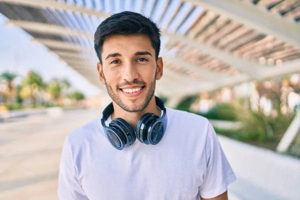 남자는 도시에서 헤드폰을 사용하여 음악을 행복하게 웃는다 — 스톡 사진