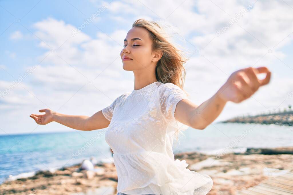 Young caucasian girl breathing with open arms at the promenade.