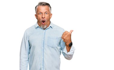 Orta yaşlı, gri saçlı, günlük giysiler giyen bir adam el ile işaret ederek şaşırdı, ağzı açık şaşkın bir şekilde ifade etti.. 