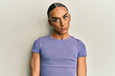 Makyaj yapan, uzun saçlı, sıradan tişörtlü, kuşkucu ve gergin bir İspanyol, sorun yüzünden surat asıyor. negatif kişi. 