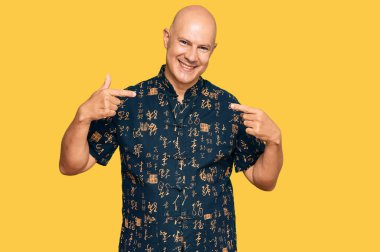 Orta yaşlı, kel, günlük kıyafetler giyen, kendine güvenen, yüzünde gülümseme olan, kendini gururlu ve mutlu gösteren bir adam.. 