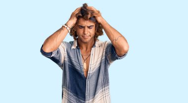 İspanyol asıllı genç adam yaz tarzı giyiniyor. Baş ağrısı, çaresiz ve stresli. Çünkü acı ve migren ağrısı var. Eller başının üstünde.. 