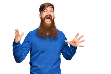 Genç İrlandalı kızıl elbiseli çılgın ve kızgın bir adam agresif bir ifadeyle bağırıyor ve kollarını kaldırıyor. hüsran kavramı. 