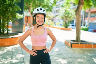 Kasabada bisiklet kaskı takarak gülümseyen güzel İspanyol bisikletçi kadın.