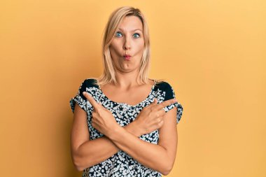 Orta yaşlı beyaz kadın parmaklarıyla farklı yönleri işaret ederek balık suratlı, şaşı gözlü, çılgın ve komik.. 