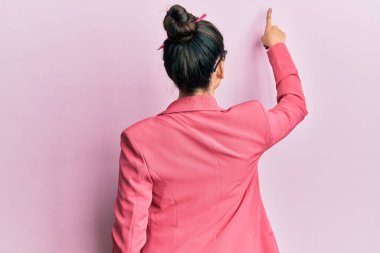 İş ceketi ve gözlük takan güzel bir orta doğulu kadın parmak ile öne doğru poz veriyor. 