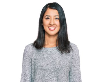 Güzel Asyalı genç bir kadın mutlu ve havalı bir gülümsemesi olan sıradan kıyafetler giyiyor. şanslı kişi. 