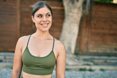 Spor giysili genç sarışın kadın şehirde spor yapıyor..