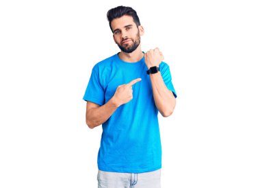 Sakallı, sıradan tişörtlü genç yakışıklı. Saati, sabırsızlığı ve rahat bir ifadeyle kameraya bakmayı işaret ediyor. 