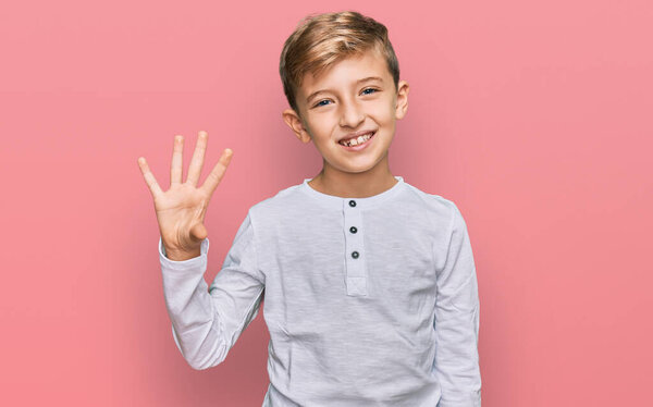 Little caucasian boy kid wearing casual clothes showing and pointing up with fingers number four while smiling confident and happy. 