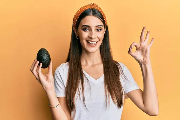 Schöne Brünette Junge Frau Mit Avocado Tut Zeichen Mit Den — Stockfoto