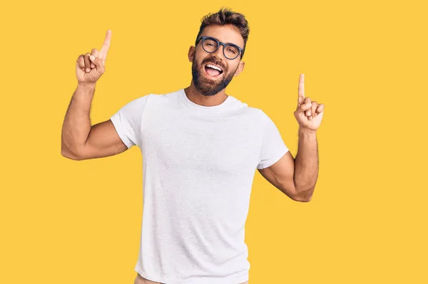Ung Latinamerikansk Man Klädd Casual Kläder Och Glasögon Ler Förvånad — Stockfoto