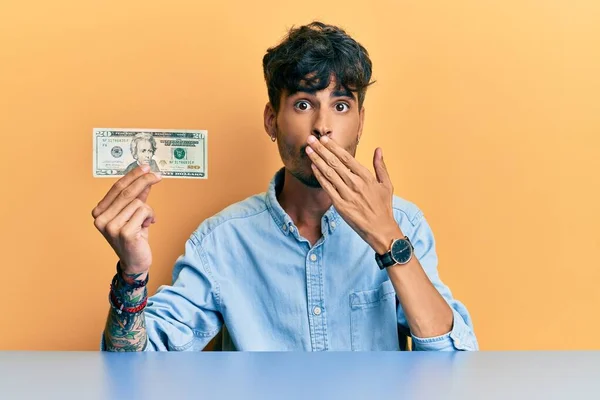 Young Hispanic Man Holding Dollar Banknote Covering Mouth Hand Shocked — Fotografia de Stock