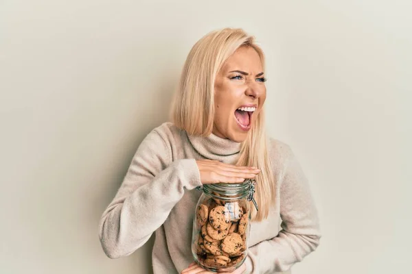 Young Blonde Woman Holding Jar Chocolate Chips Cookies Angry Mad — ストック写真