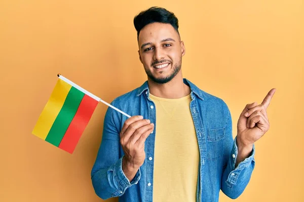 Joven Árabe Sosteniendo Bandera Lithuania Sonriendo Feliz Señalando Con Mano —  Fotos de Stock