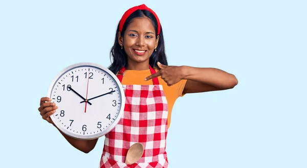 Junges Indisches Mädchen Kochschürze Hält Große Uhr Mit Zeigefinger Auf — Stockfoto