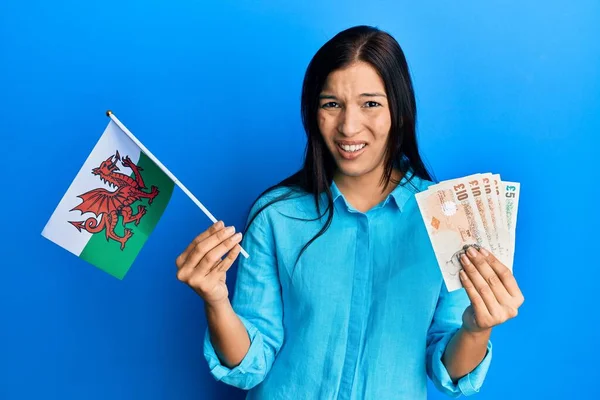 Молодая Латиноамериканка Флагом Уэльса Банкнотами Лице Выглядящая Скептически Саркастично Удивленная — стоковое фото