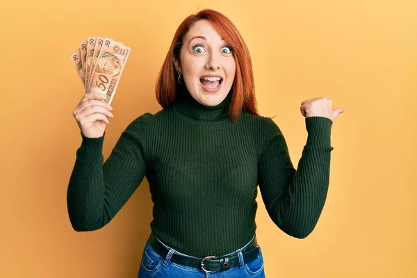 Mulher Ruiva Bonita Segurando Notas Reais Brasileiras Apontando Polegar Para — Fotografia de Stock