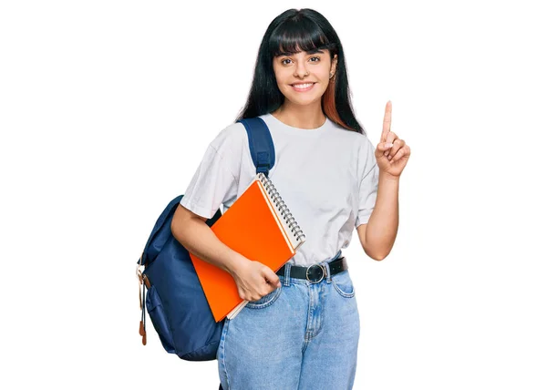 Νεαρή Ισπανίδα Που Φοράει Φοιτητικό Σακίδιο Και Κρατάει Βιβλίο Έκπληκτη — Φωτογραφία Αρχείου