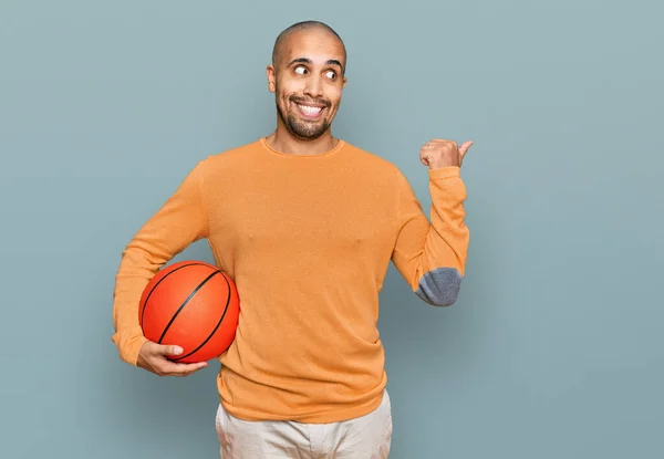 Pria Dewasa Hispanik Memegang Bola Basket Menunjuk Jempol Samping Tersenyum — Stok Foto