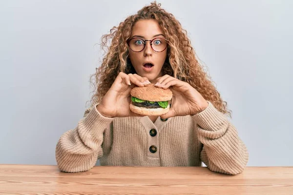 Beautiful Caucasian Teenager Girl Eating Tasty Classic Burger Afraid Shocked — Stock Photo, Image