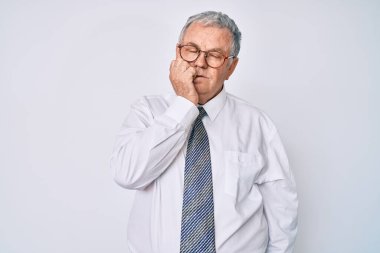 İş kıyafetleri giyen yaşlı gri saçlı adam gergin ve gergin görünüyor. Ağzı tırnak yiyen ellerle. anksiyete. 