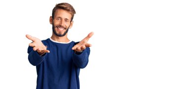 Sakallı yakışıklı, sıradan bir süveter giyen neşeli gülümseyen, yardım eli uzatan ve kabullenen bir adam.. 