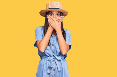 Yaz şapkası takan genç İspanyol kadın yanlışlıkla elleri ile ağzını kapatırken şok oldu. gizli kavram. 