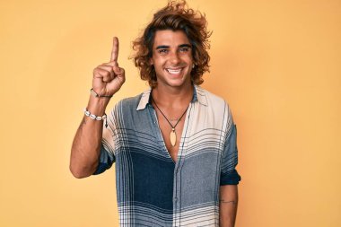 Yaz tarzı giyinmiş genç bir İspanyol başarılı bir fikir işaret ediyor. Heyecanlı ve mutlu. Bir numara.. 