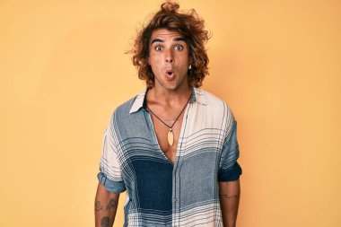 Yaz stili giyinen genç İspanyol adam korkmuş ve ağzı açık şaşırmış bir şekilde şaşkınlık ifadesi takınlığa uğramış. 