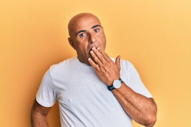 Normal beyaz tişört giyen olgun bir Orta Doğulu adam ağzıyla ağzını kapatmaktan sıkılmış. Huzursuz ve uykulu.. 