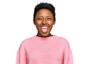 Genç Afro-Amerikan kadın, günlük kıyafetler giyip, dillerini komik bir ifadeyle dışarı çıkarıyor. duygu kavramı. 