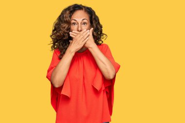 Gündelik kıyafetler giyen orta yaşlı İspanyol kadın yanlışlıkla elleri ile ağzını kapatırken şok oldu. gizli kavram. 