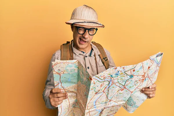 Middle Age Bald Man Wearing Explorer Hat Holding Map Winking — Stockfoto