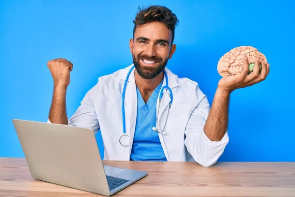 Jovem Hispânico Vestindo Uniforme Médico Trabalhando Clínica Segurando Cérebro Gritando — Fotografia de Stock