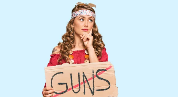 Young Blonde Girl Wearing Hippie Style Holding Guns Warning Banner — Stok fotoğraf